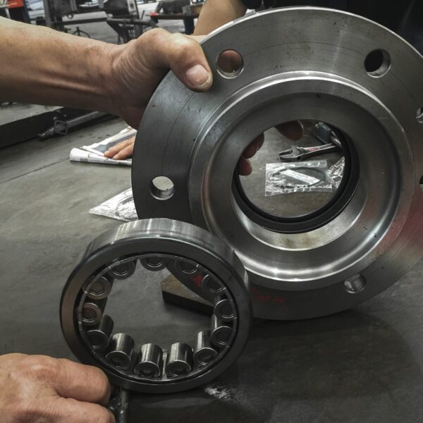 Industrial bearings part. Unassembled, with the mechanic man. Large industrial bearing and flange.