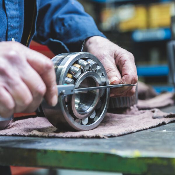 Manufacturing And Assembly Mechanic measuring industrial bearing.