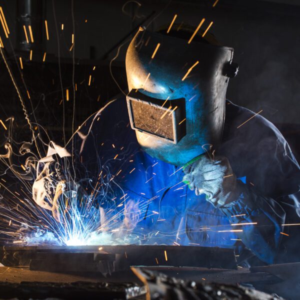 welding argon, Results welding on the metal of the foreground Welder in action, sparks flying.