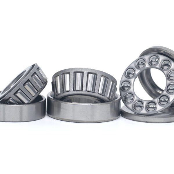Tapered roller and thrust ball bearings isolated on white Three metallic roller bearings on white.